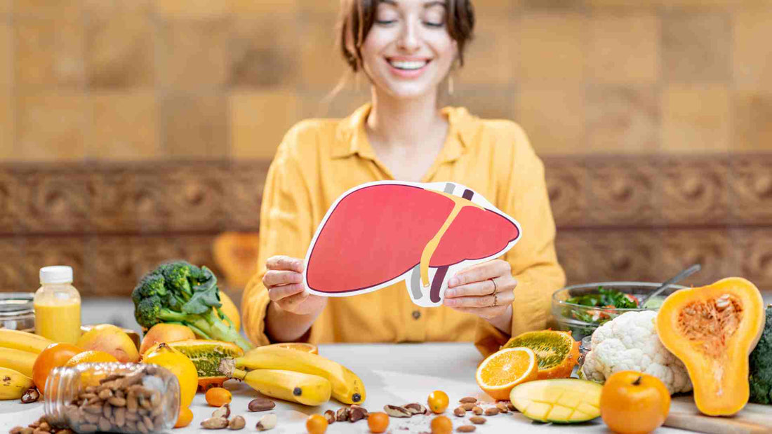 Person holding an illustrated liver icon, surrounded by a variety of fresh fruits, vegetables, and nuts, emphasizing a healthy diet for liver health.